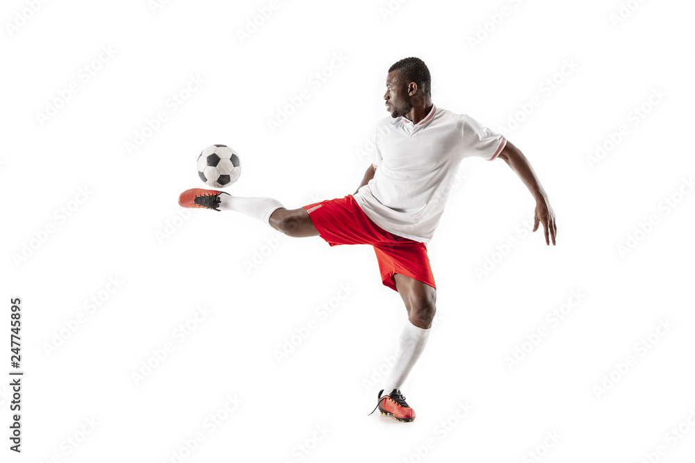 Professional african american football soccer player in motion isolated on white studio background. Fit jumping man in action, jump, movement at game.