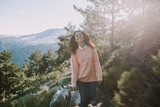 The pretty brunette girl walks towards the camera with a big smile. Enjoy a beautiful sunny day and a completely clear day. Wear a pair of jeans and a coral colored sweater.
