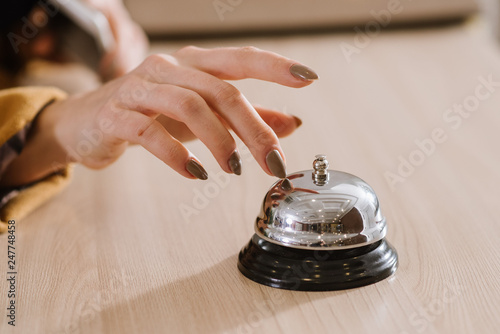 A womans hand on the hotel bell at the reception