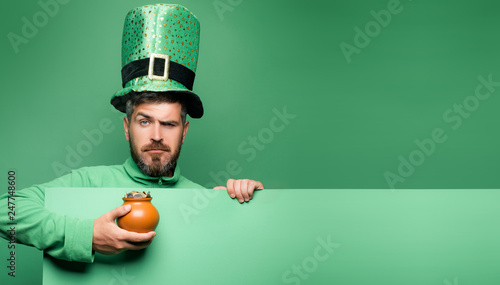 Pot of gold. Green patricks background. Man in Saint Patrick's Day leprechaun party hat having fun on green background. photo
