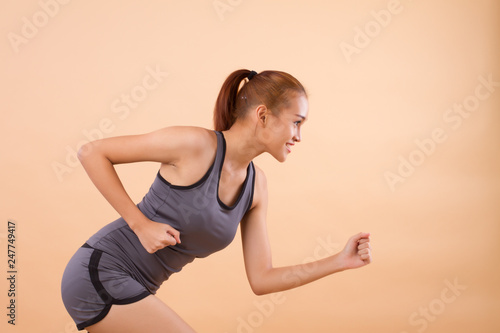 happy smiling asian woman running  portrait of woman running, jogging, working out, exercising for healthy lifestyle concept  tan skin asian young adult woman model © 9nong