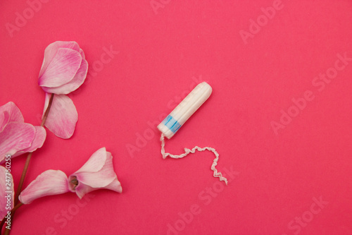 Hygienic tampons on a pink background with flowers.