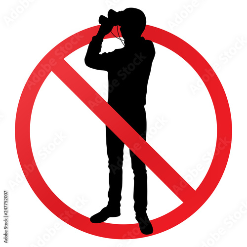 Silhouette of a guy with binoculars under a forbidden sign