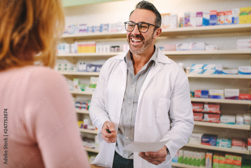 Helpful pharmacist dealing with a woman customer