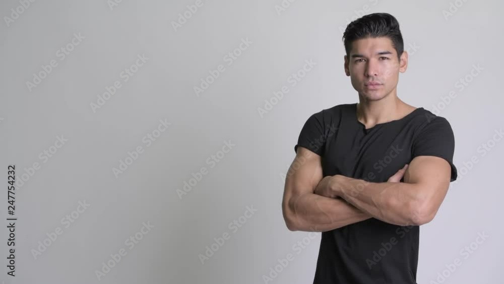 Profile view of young handsome multi-ethnic man with arms crossed Profile view of young handsome multi-ethnic man with arms crossed