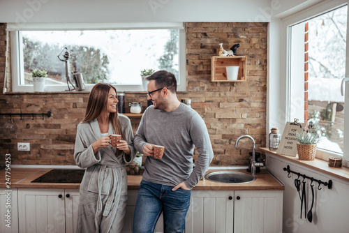 Weekend mornings. Millennial couple having tea on winter morning. photo