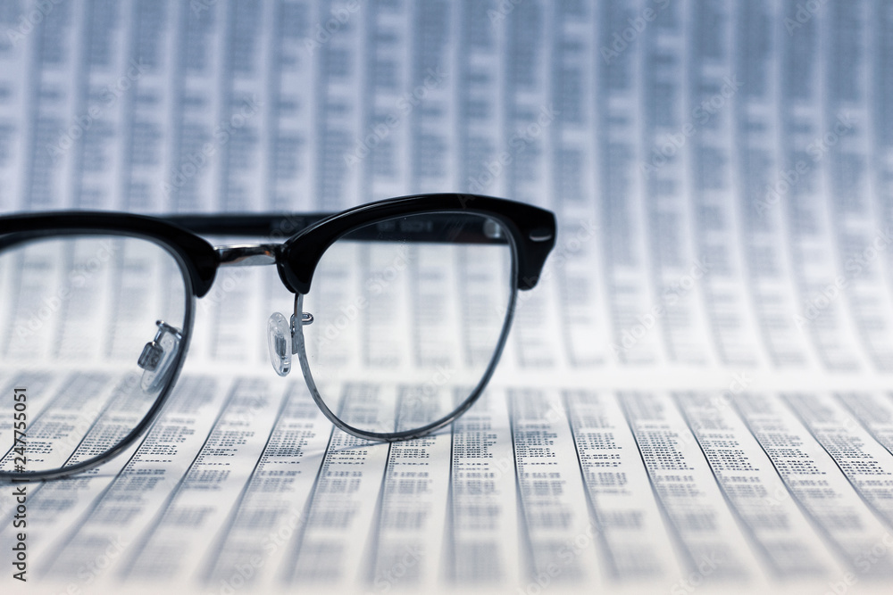 Glasses on financial reports. (selective focus at glasses) Glasses on financial reports. (selective focus at glasses)