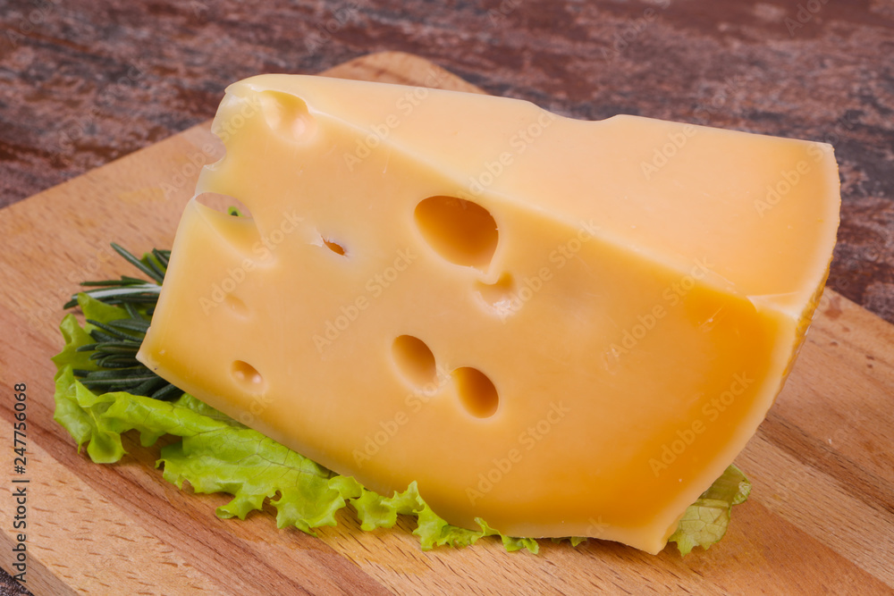 Maasdam cheese in the board served salad leaves Maasdam cheese in the board served salad leaves