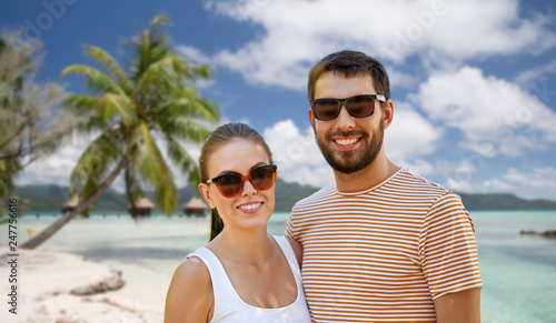 travel, tourism and people concept - happy couple in sunglasses outdoors in summer over tropical beach background in french polynesia © Syda Productions