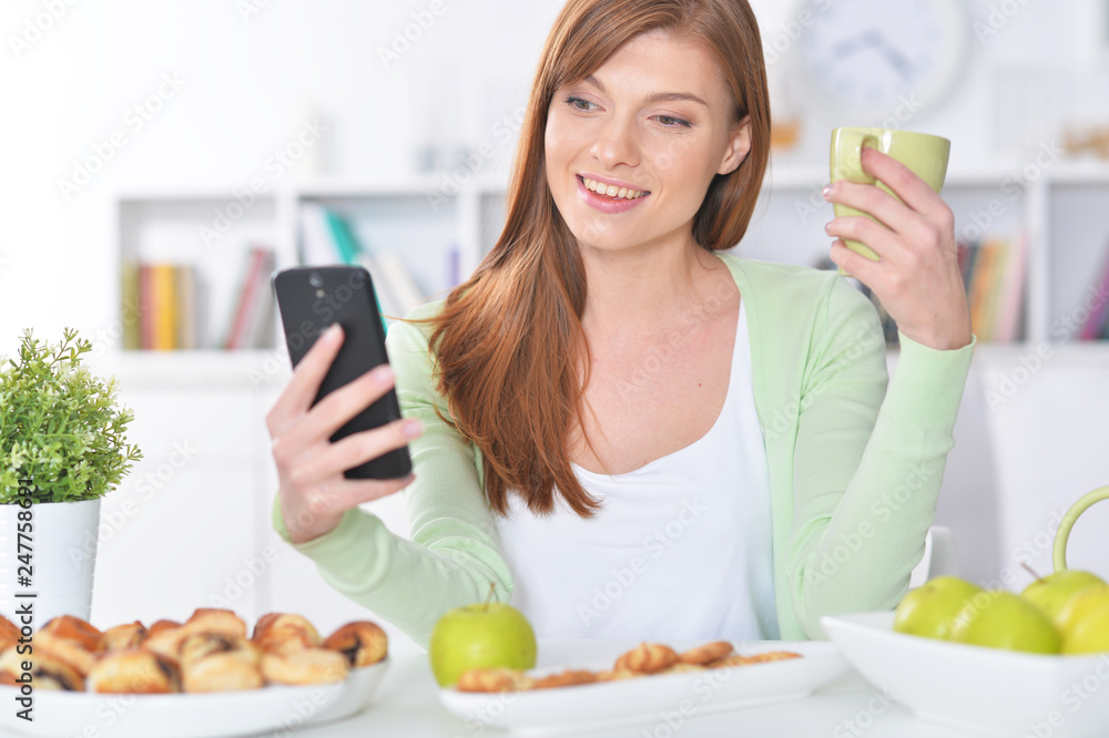 Beautiful woman taking selfie with smartphone at kitchen Beautiful woman taking selfie with smartphone at kitchen