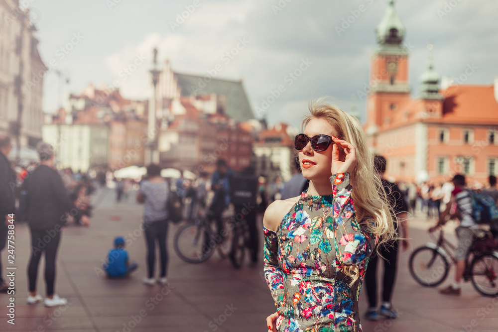 Street stylsh portrait of young blodnie cheerful girl walking in the old town. Vacation, travelling, beauty concept