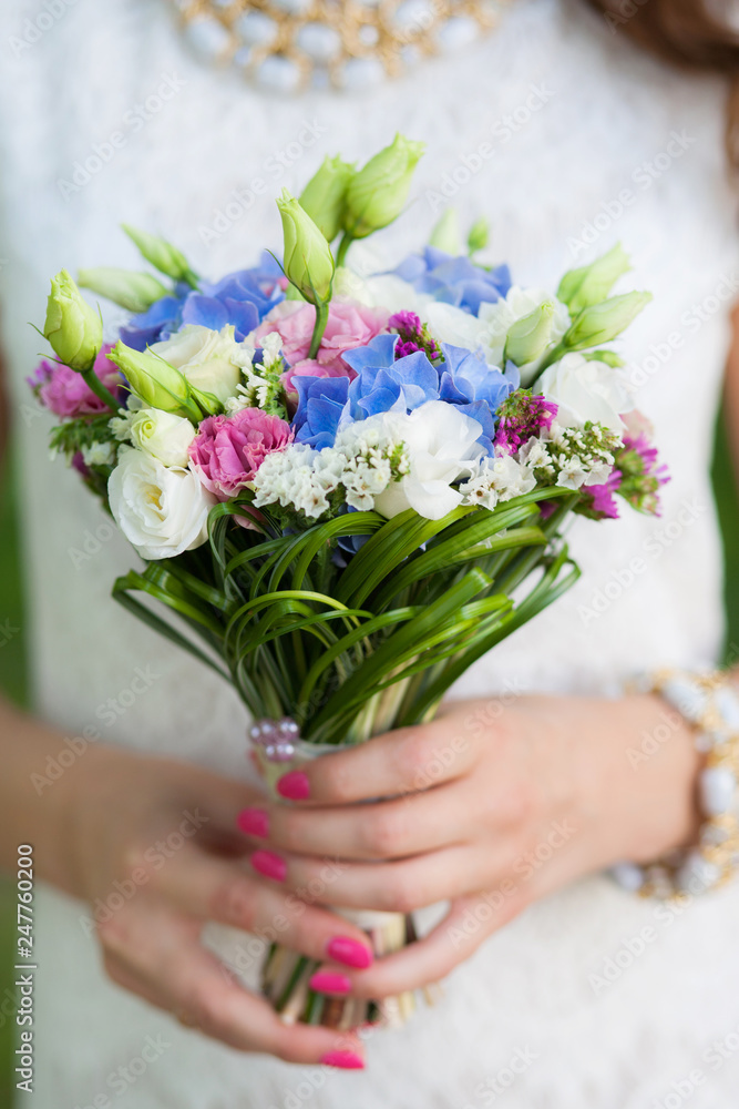 Φωτογραφία Closeup view of cute small colorful bridal wedding bouquet of flowers in hands of young beautiful bride