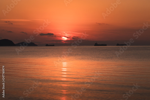 view of the orange sun falling over the sea and the beautiful sky