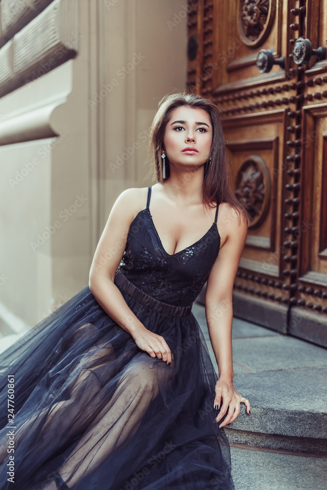 Fototapeta premium Fashionable close up street portrait of brunette beautiful girl walking in old town of Riga. Beauty, fashion concept