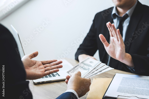 Anti bribery and corruption concept, Business man refusing and don't receive money banknote offered from business people to accept agreement contract of investment deal © Ngampol