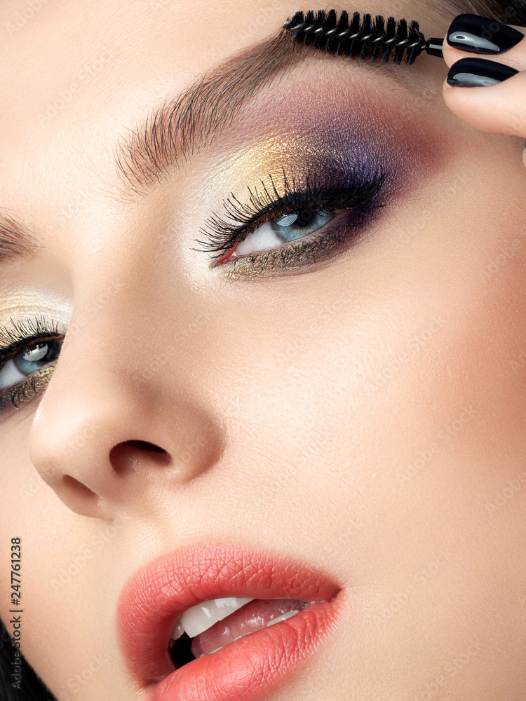 Closeup portrait of beautiful woman combing her eyebrow looking at camera.  Studio beauty shot. Perfect skin and fashion makeup. Stock Photo | Adobe  Stock