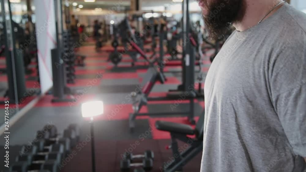 Handsome athletic man training dumbbell biceps in the gym. Handsome athletic man training dumbbell biceps in the gym.