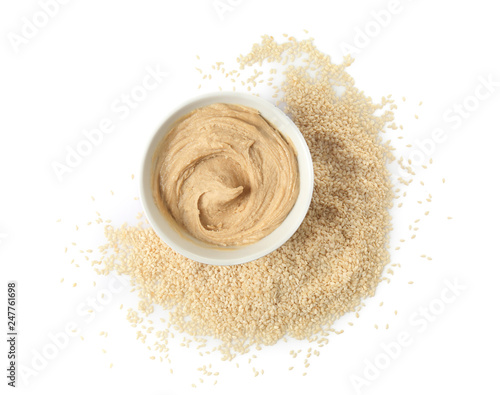 Bowl of tasty tahini with sesame seeds on white background photo