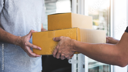 Delivery mail man giving parcel box to recipient, Young owner accepting of cardboard boxes package from post shipment, Home courier and delivery service mind concept