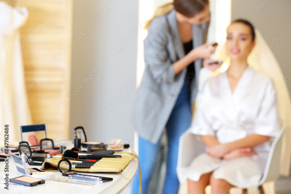 Professional makeup artist working with young bride at home Professional makeup artist working with young bride at home