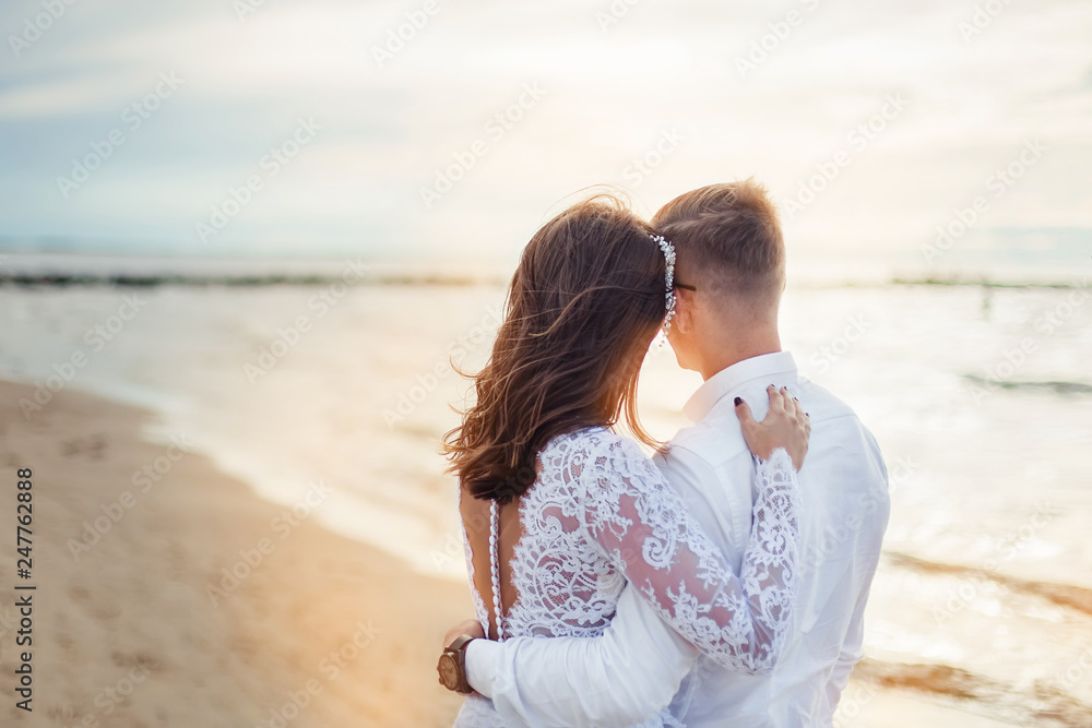 Obraz premium Happy young romantic cheerful loving wedding couple walking on the beach of sea. Happiness, couple, love concept