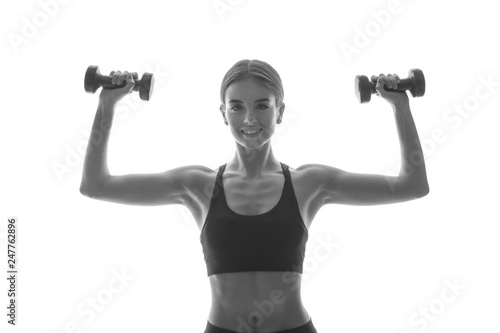 Portrait of sporty woman with dumbbells on white background