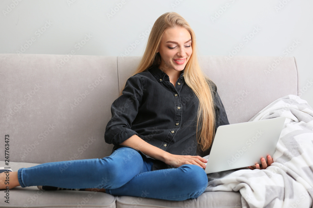 Beautiful young woman using laptop at home