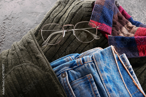 Stylish men's clothes with eyeglasses on grunge background, closeup