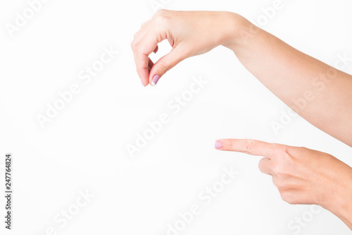 Closeup view of female hands holding nothing isolated on white background. WOman pointing at something with index finger. Put anything you need in empty place. Horizontal color photography.