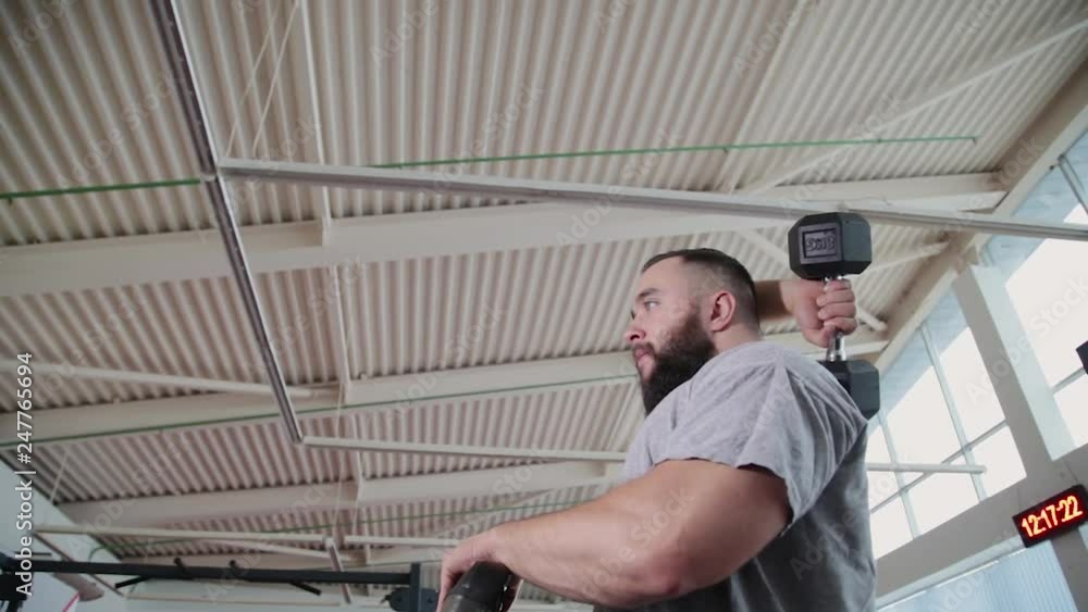 Handsome athletic man trains triceps on the block simulator in the gym. Handsome athletic man trains triceps on the block simulator in the gym.