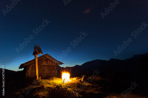 Lagerfeuer in den Alpen bei einer Berghütte