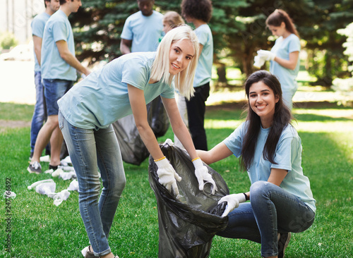 Fotografie Volunteers collecting recyclable plastic bottles in park