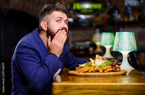 Man received meal with fried potato fish sticks meat. Delicious meal. Enjoy meal. High calorie snack. Cheat meal concept. Hipster hungry eat pub fried food. Manager formal suit sit at bar counter