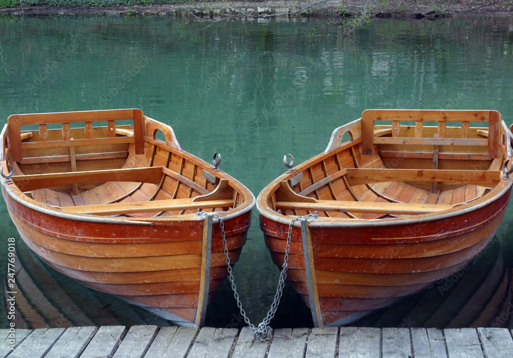 Rowboats parked in a row near a clear water lake