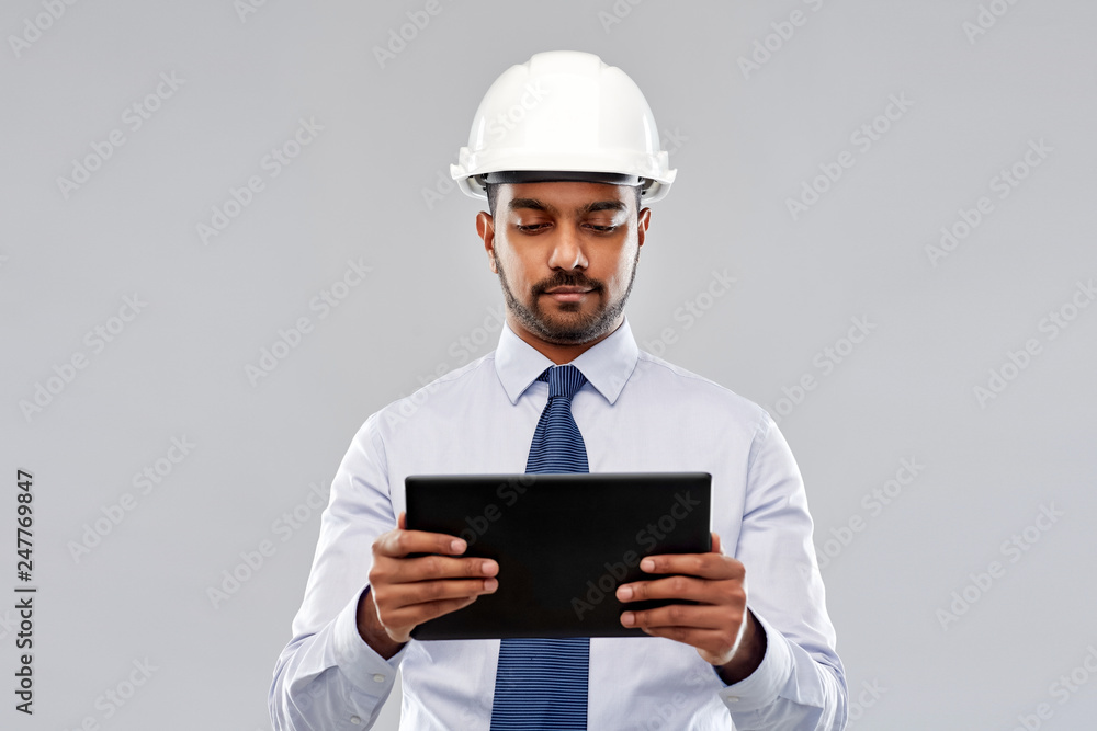 architecture, technology, construction business and building - indian architect or businessman in helmet with tablet computer over grey background architecture, technology, construction business and building - indian architect or businessman in helmet with tablet computer over grey background