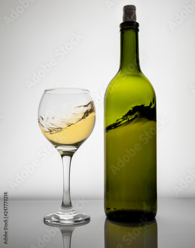 bottle and glass of white wine isolated on white background