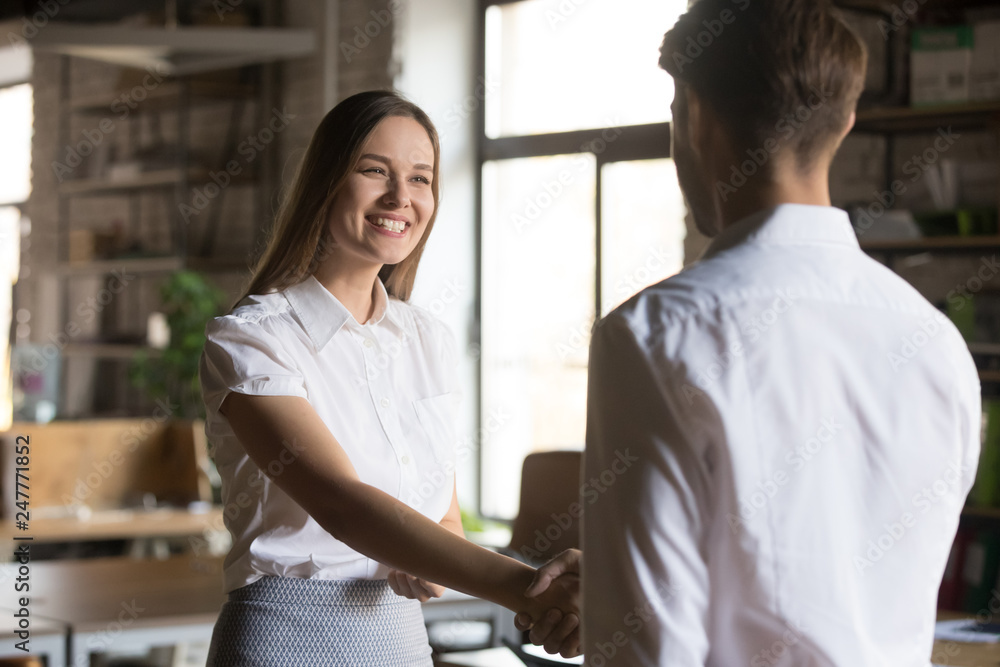 Fototapeta premium Male boos handshake excited female employee greeting with promotion