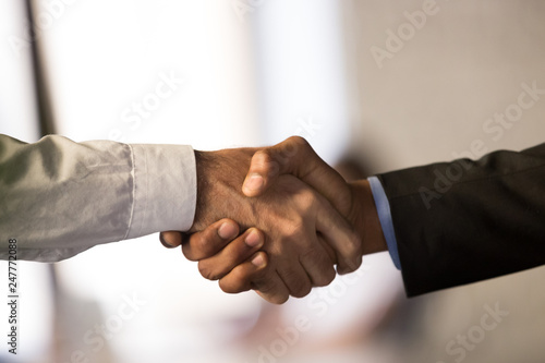 Close up of male employees handshake closing deal