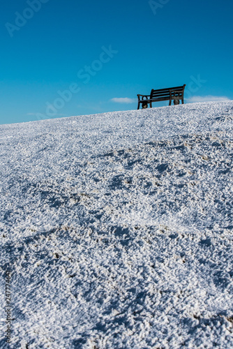 Seat on Cleeve Hill skylined on a bright snowy winters day, Cotswolds, Gloucester UK photo