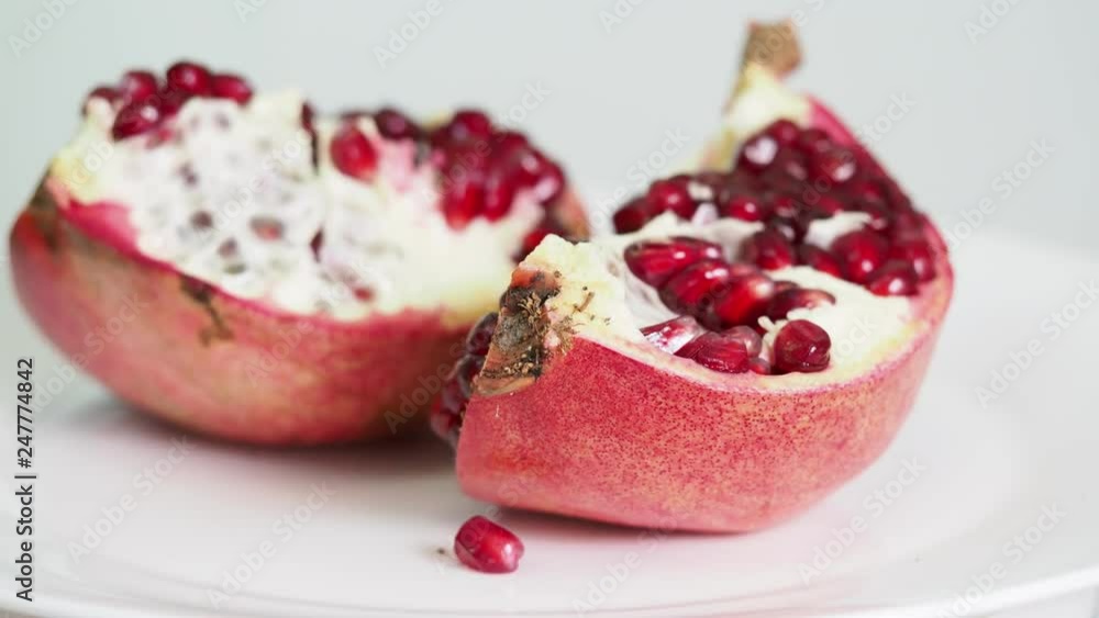 splitted pomegranate fruit on plate rotates splitted pomegranate fruit on plate rotates