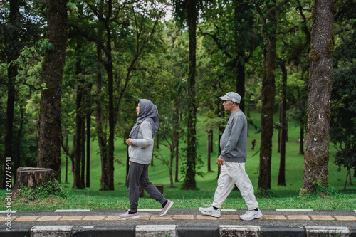 two senior couple walking together in the park doing som exercising