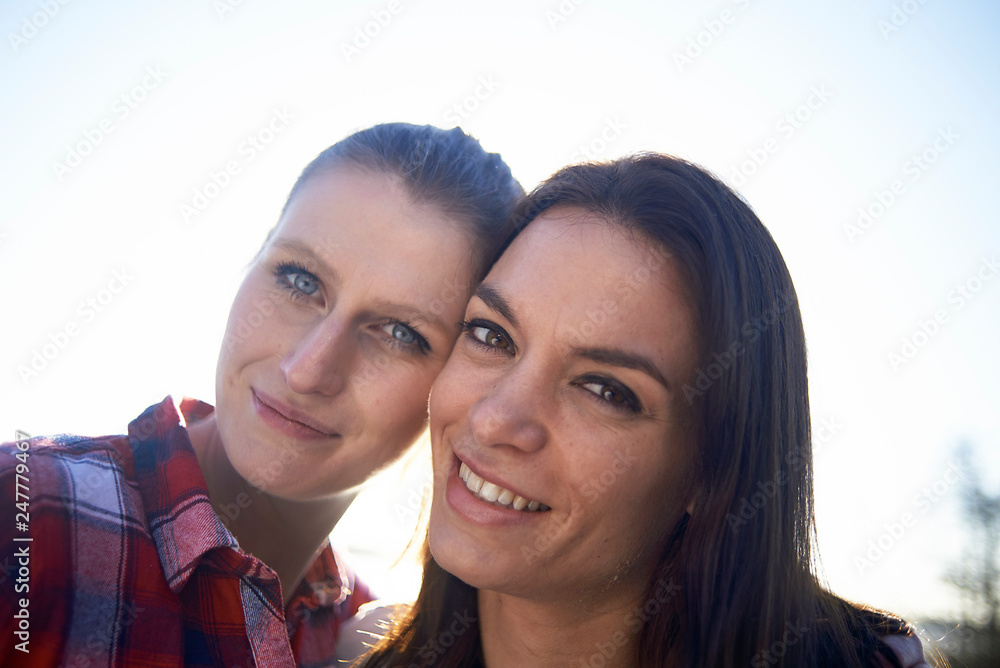 Portraits of a young lesbian couple enjoying their time together around a lake and jetty in winter sunshine Portraits of a young lesbian couple enjoying their time together around a lake and jetty in winter sunshine
