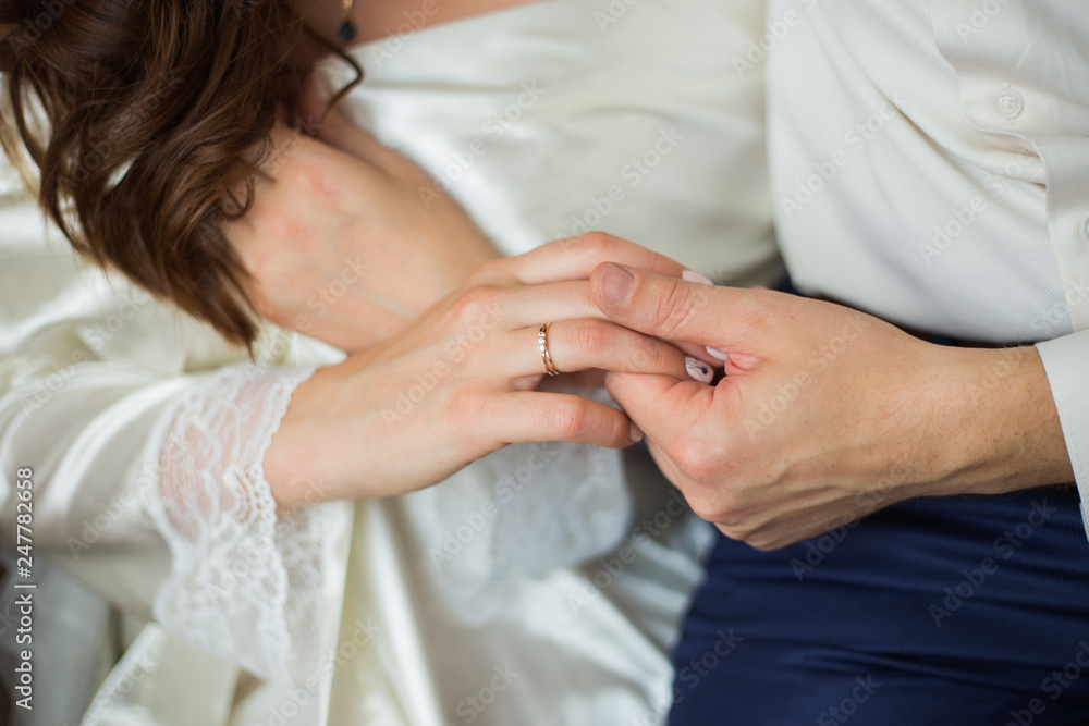 Closeup view of male and female hands holding. Man and woman sitting together. Horizontal color image.