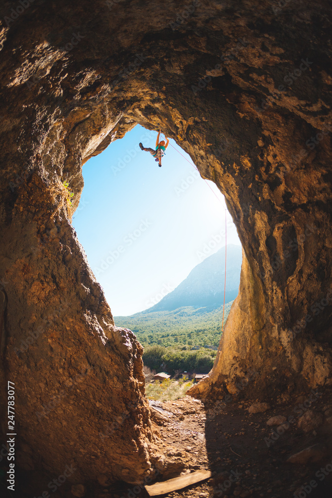 Rock climber climbs into the cave.