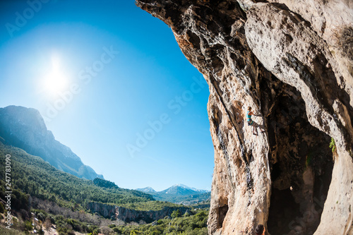 Rock climber on the background of beautiful mountains and blue sky.