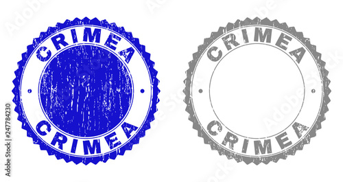 Grunge CRIMEA stamps isolated on a white background. Rosette seals with grunge texture in blue and gray colors. Vector rubber stamp imitation of CRIMEA title inside round rosette.
