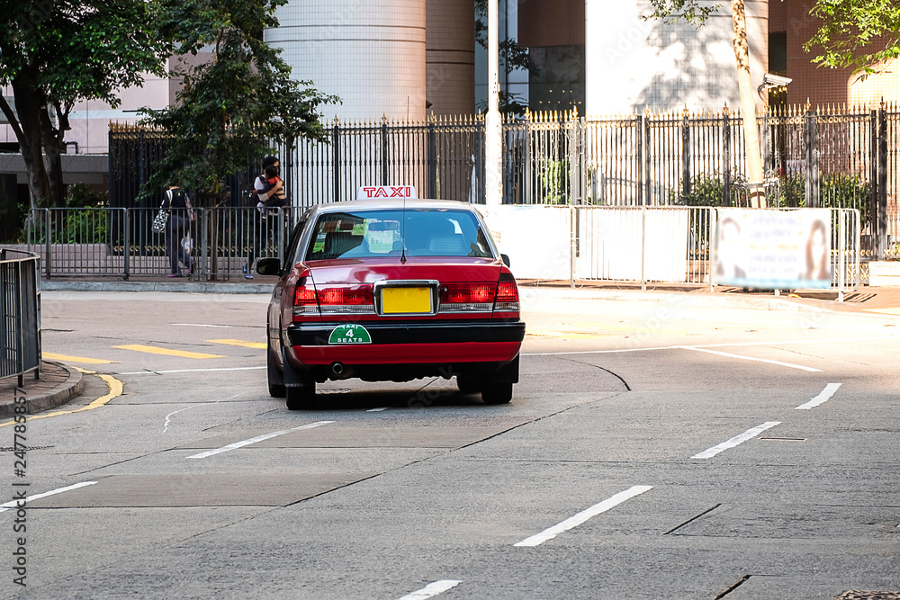 Fototapeta premium red and white colors Taxi cab, symbol of HK, on Hollywood road near Central and Sheung Wan district; Hong Kong, China, 16 December 2018