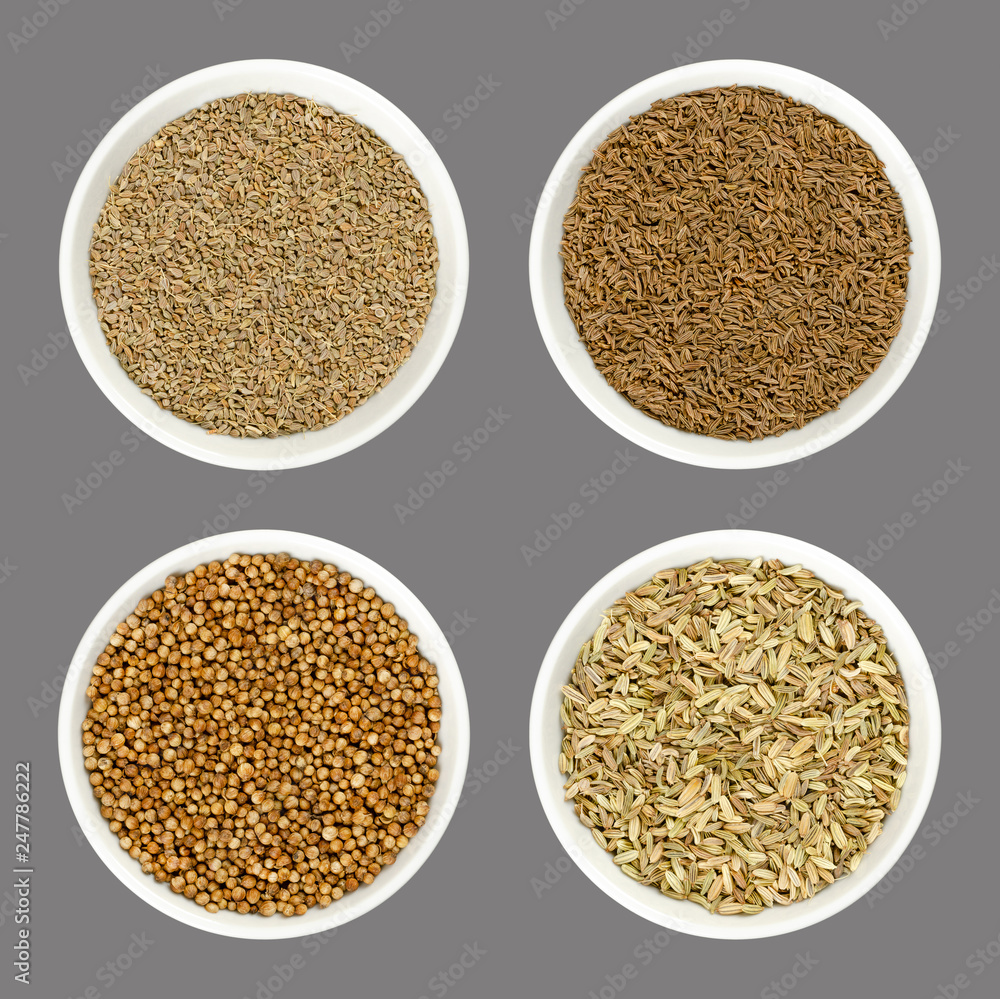 Anise, caraway, coriander and fennel seeds in white bowls. Also aniseed, Persian cumin or cilantro. Dried spices to flavor bread and for herbal medicine. Food photo, closeup, from above, over gray. Anise, caraway, coriander and fennel seeds in white bowls. Also aniseed, Persian cumin or cilantro. Dried spices to flavor bread and for herbal medicine. Food photo, closeup, from above, over gray.