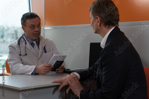 A doctor with patient in clinic room.