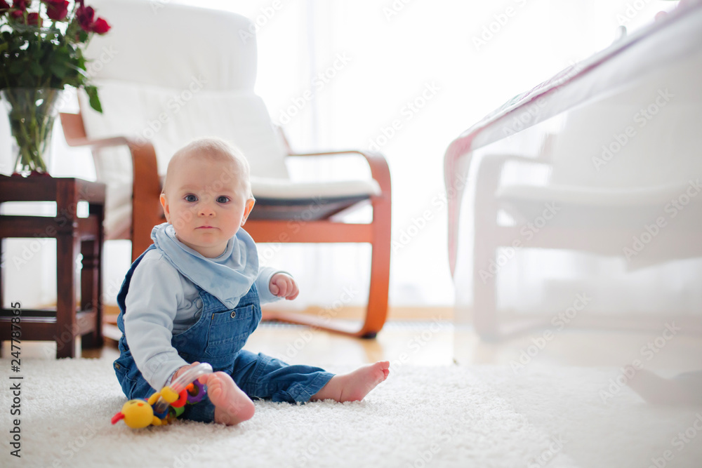 Cute little toddler baby boy, playing at home on the floor in bedroom Cute little toddler baby boy, playing at home on the floor in bedroom